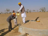 Hommes venant puiser l'eau - Citerne enterrée et impluvium surface sablée
