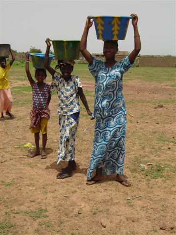 Femmes transportant de l'eau puisée dans le marigot