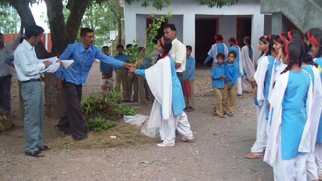 Distribution d’une pousse d’arbre aux enfants pour la planter dans leur maison (initiative « un enfant un arbre »), ici à l’écol