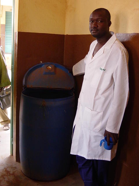 Agent de santé du CSCom montrant la réserve d'eau potable