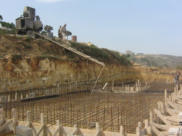 La bétonnière motorisée et la goulotte de descente du béton sur le radier de la station d'épuration