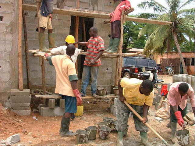 Maçons à l'oeuvre sur le chantier de construction du bloc sanitaire - Nukafu.