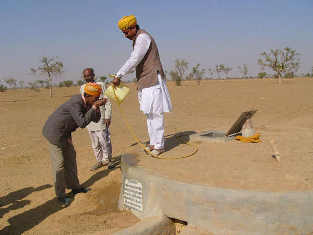 Hommes venant puiser l'eau - Citerne enterrée et impluvium surface sablée